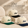 Three Dad snapback caps in different color combinations on a neutral background.